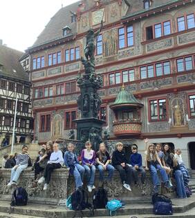 Die Kinder sitzen am Neptunbrunnen auf dem Marktplatz